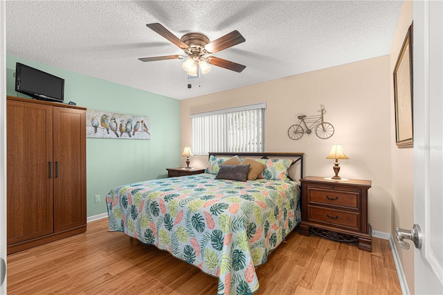 bedroom featuring a textured ceiling, light hardwood / wood-style floors, and ceiling fan