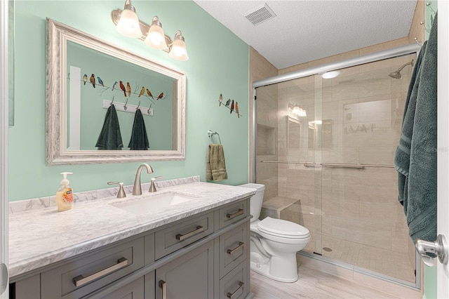 bathroom with vanity, toilet, a shower with door, and hardwood / wood-style floors