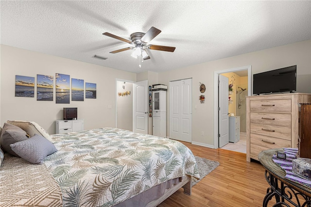 bedroom featuring ceiling fan, a textured ceiling, light wood-type flooring, and ensuite bath