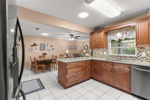 kitchen featuring sink, kitchen peninsula, ceiling fan, stainless steel appliances, and decorative backsplash