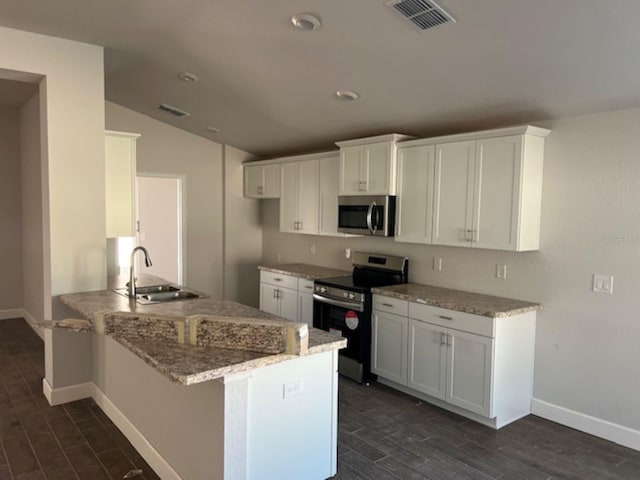 kitchen featuring light stone countertops, sink, stainless steel appliances, kitchen peninsula, and white cabinets