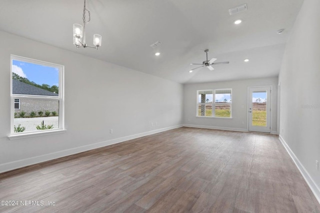 unfurnished room with ceiling fan with notable chandelier, light hardwood / wood-style floors, and lofted ceiling