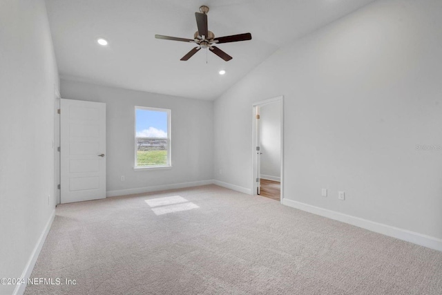 unfurnished bedroom with ceiling fan, lofted ceiling, and light carpet