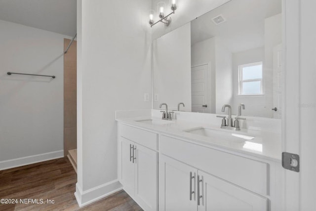 bathroom with a shower, hardwood / wood-style floors, and vanity