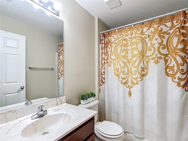 bathroom featuring vanity, toilet, and a textured ceiling