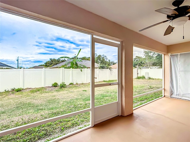 unfurnished sunroom featuring ceiling fan