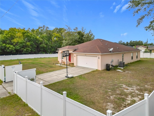 view of side of home with a garage, a yard, and central AC