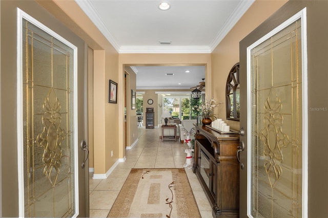 foyer entrance with crown molding and light tile patterned floors