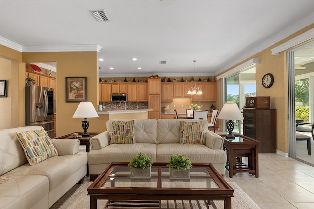 living room featuring sink, crown molding, a notable chandelier, and light tile patterned flooring