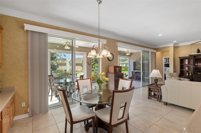 tiled dining area featuring crown molding and ceiling fan with notable chandelier