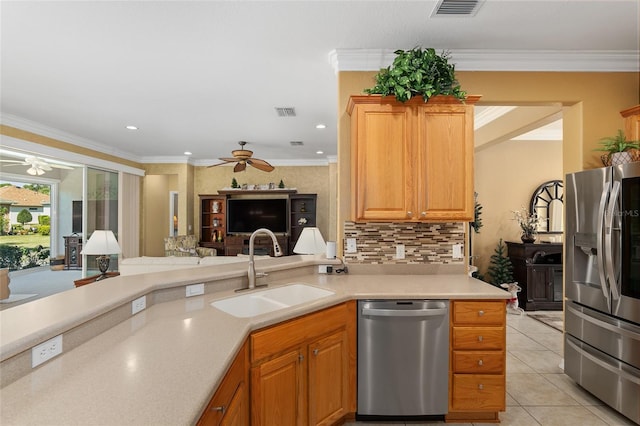 kitchen with sink, light tile patterned flooring, kitchen peninsula, stainless steel appliances, and ornamental molding