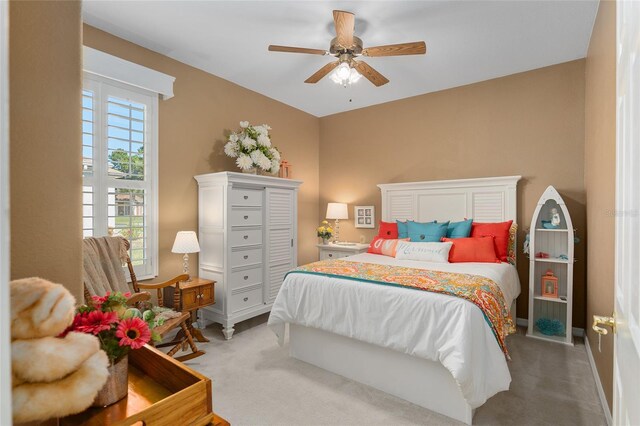 carpeted bedroom featuring multiple windows and ceiling fan