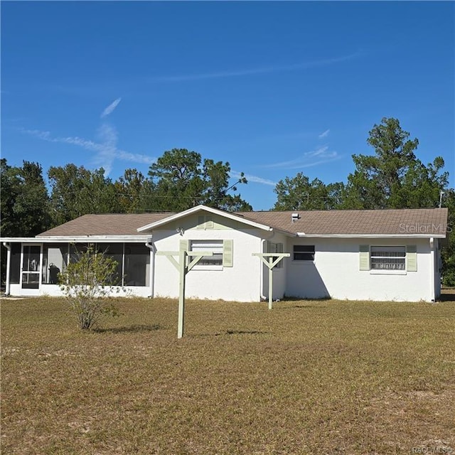 ranch-style home with a front lawn and a sunroom