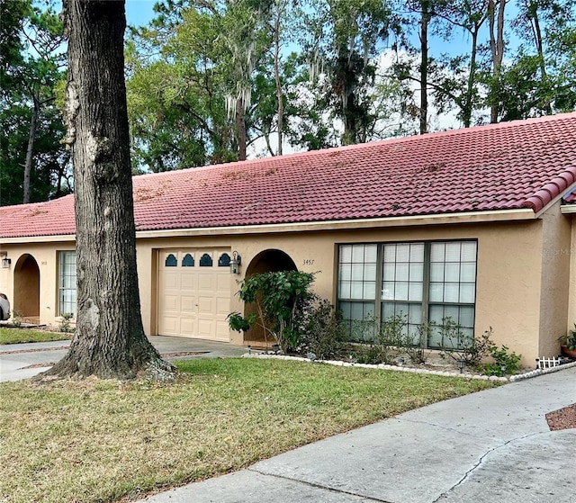 view of front of property with a garage and a front lawn