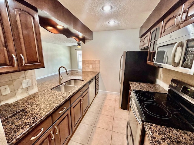 kitchen with a textured ceiling, sink, appliances with stainless steel finishes, and tasteful backsplash