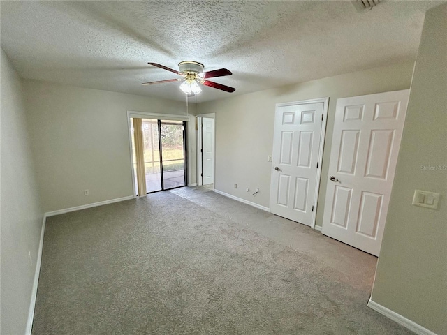 carpeted spare room with a textured ceiling and ceiling fan