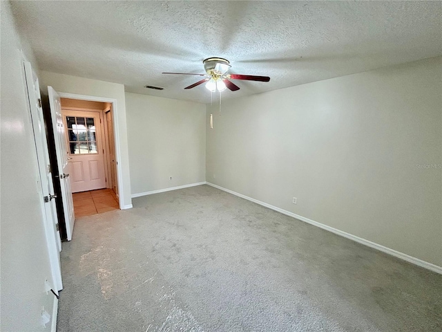 unfurnished bedroom with ceiling fan, a textured ceiling, and light carpet