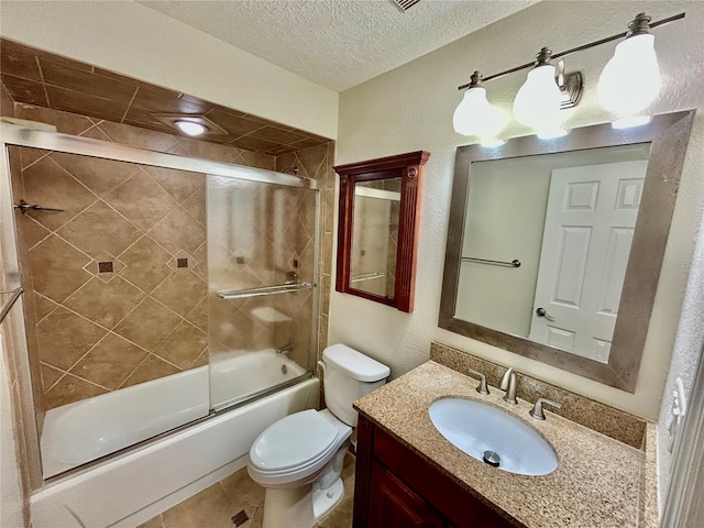 full bathroom with tile patterned flooring, a textured ceiling, combined bath / shower with glass door, vanity, and toilet