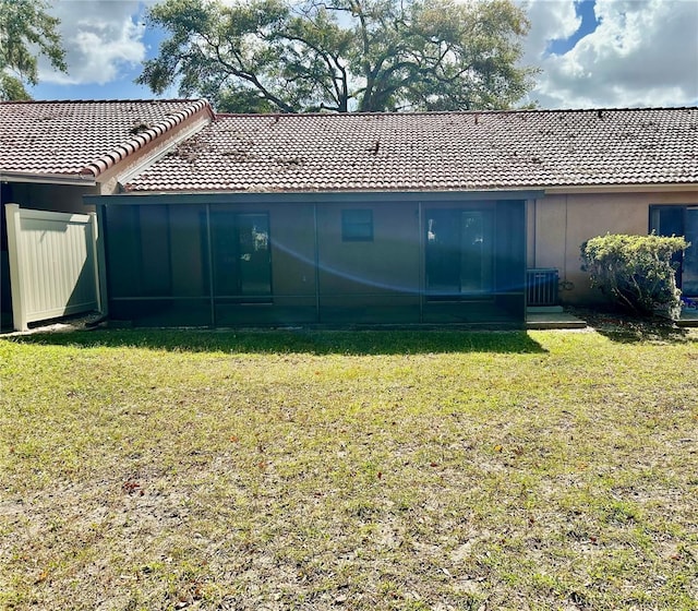 rear view of house with a lawn and central AC