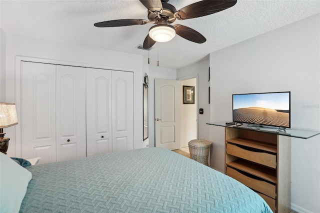 bedroom featuring ceiling fan, a closet, and a textured ceiling