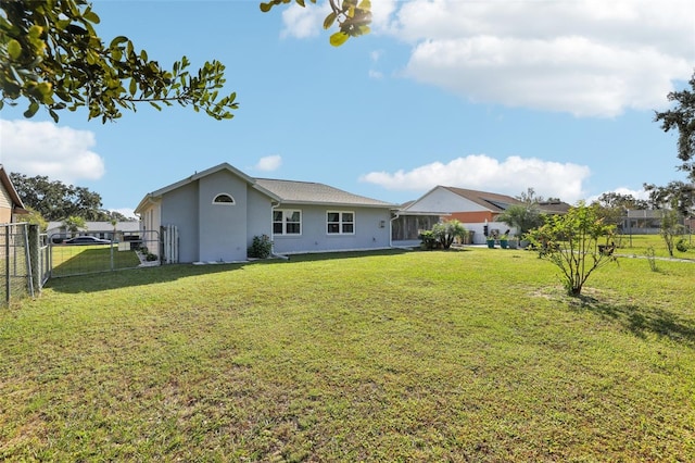 rear view of house featuring a yard