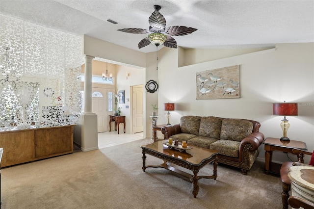 carpeted living room featuring a textured ceiling, ornate columns, high vaulted ceiling, and ceiling fan with notable chandelier