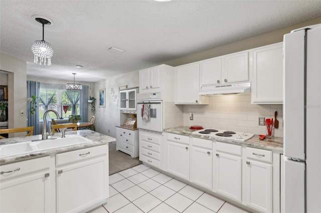 kitchen with pendant lighting, white appliances, white cabinetry, and sink