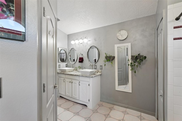 bathroom with vanity, a textured ceiling, and tile patterned floors