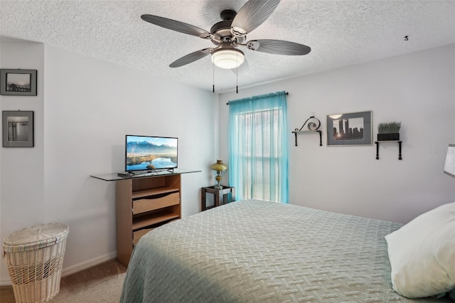 carpeted bedroom featuring ceiling fan and a textured ceiling