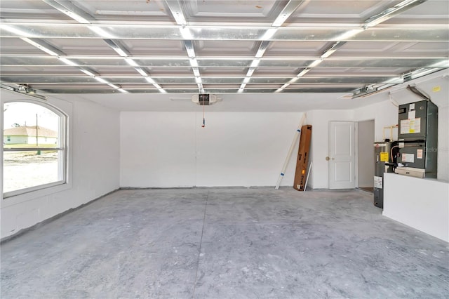 garage featuring a garage door opener, water heater, and heating unit