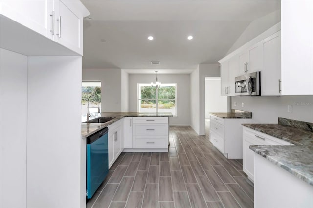 kitchen featuring white cabinets, light wood-type flooring, lofted ceiling, and black dishwasher