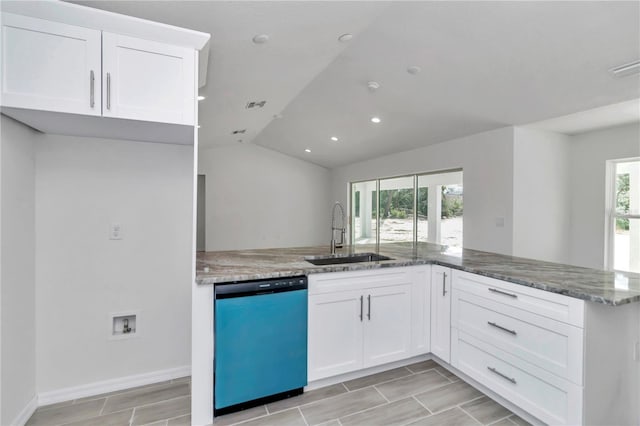 kitchen featuring sink, plenty of natural light, stainless steel dishwasher, white cabinets, and vaulted ceiling