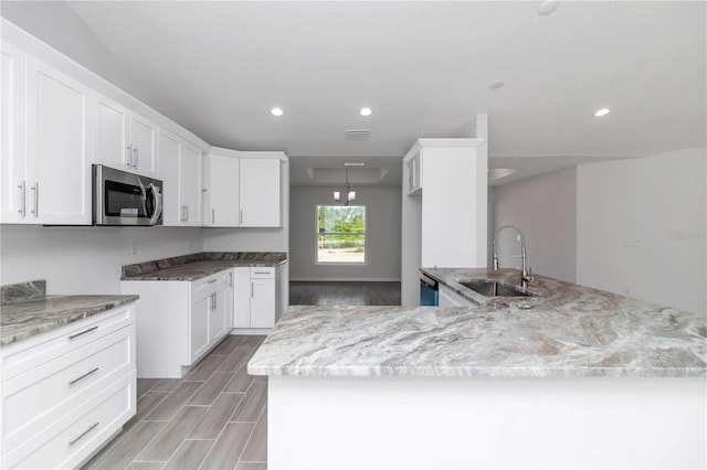 kitchen with stainless steel appliances, light hardwood / wood-style floors, white cabinetry, sink, and light stone counters