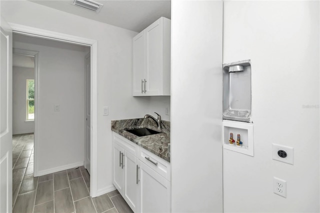 washroom featuring hookup for an electric dryer, cabinets, sink, and washer hookup