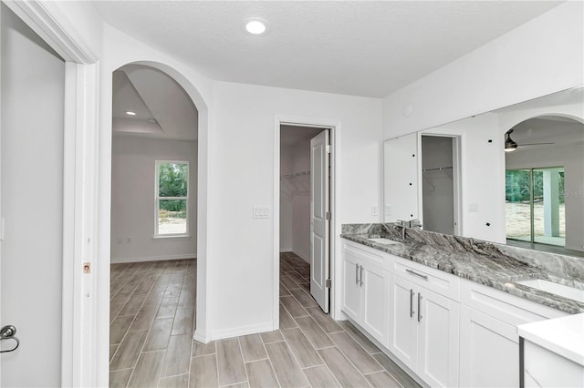 bathroom featuring a textured ceiling, vanity, hardwood / wood-style flooring, and ceiling fan