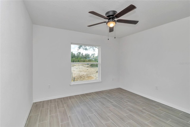 empty room with a textured ceiling, ceiling fan, and light hardwood / wood-style flooring