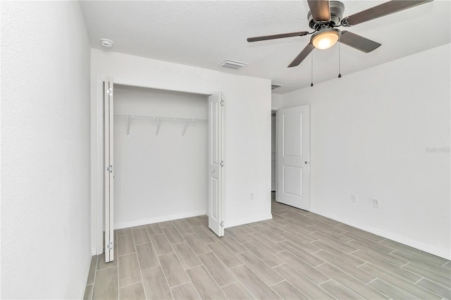 unfurnished bedroom featuring a textured ceiling, light hardwood / wood-style flooring, ceiling fan, and a closet