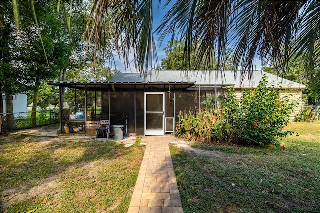 view of outbuilding with a sunroom and a lawn