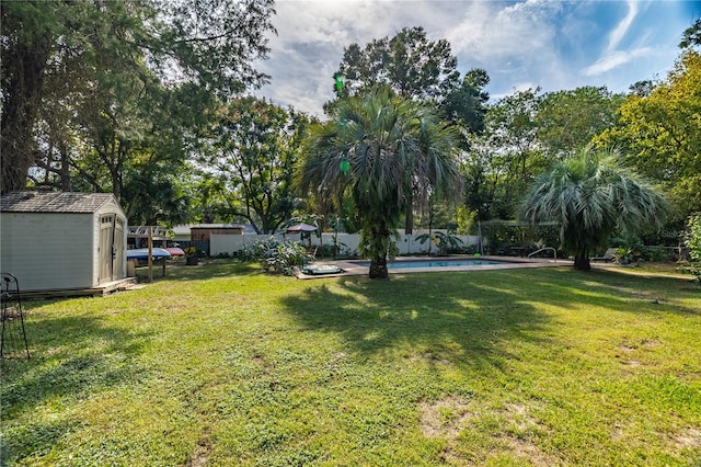 view of yard with a storage shed and a fenced in pool