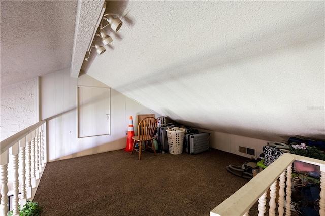 bonus room with lofted ceiling with beams, a textured ceiling, and carpet flooring