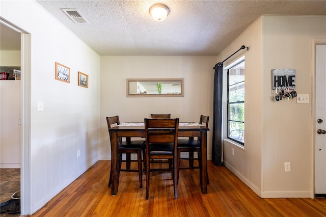 dining room with a textured ceiling and wood-type flooring