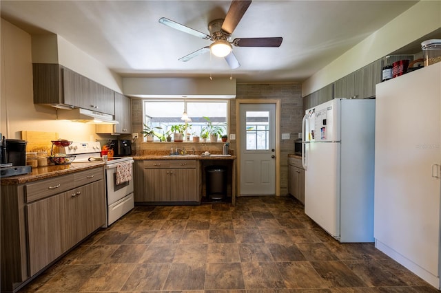 kitchen featuring sink, electric range, ceiling fan, dark stone counters, and white fridge