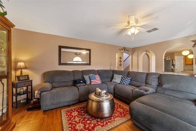 living room featuring ceiling fan and wood-type flooring