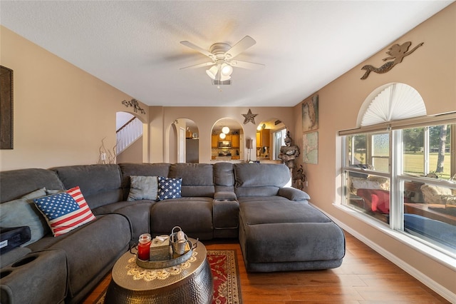 living room featuring ceiling fan, a textured ceiling, and hardwood / wood-style floors