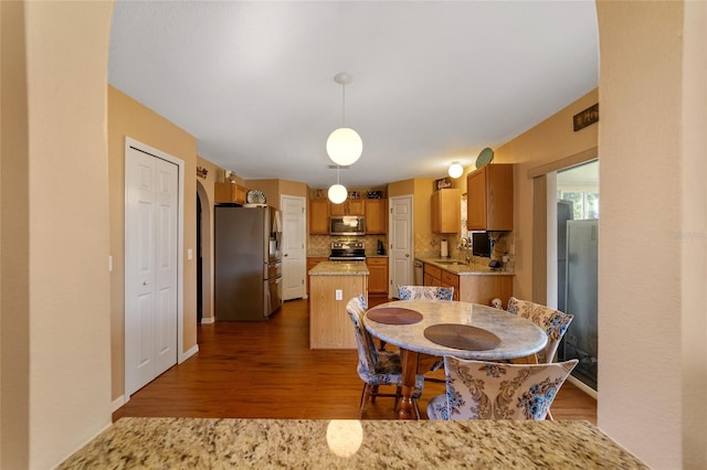 dining space featuring sink and dark wood-type flooring