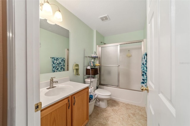 full bathroom featuring combined bath / shower with glass door, a textured ceiling, toilet, vanity, and tile patterned floors