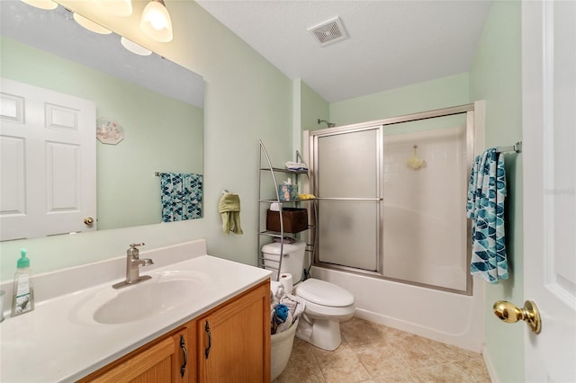 full bathroom featuring combined bath / shower with glass door, a textured ceiling, toilet, vanity, and tile patterned flooring