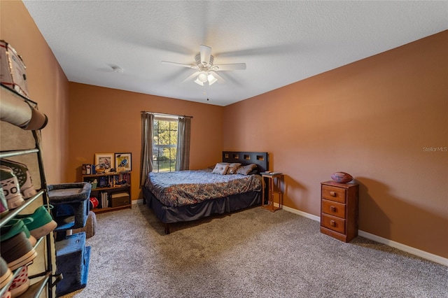 bedroom with ceiling fan, carpet, and a textured ceiling