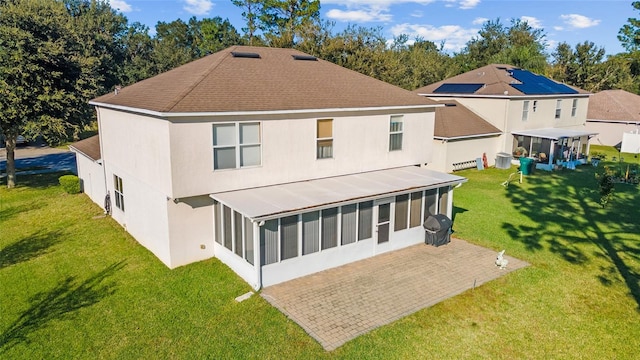 rear view of house with a sunroom and a lawn