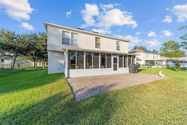 rear view of property with a sunroom and a lawn